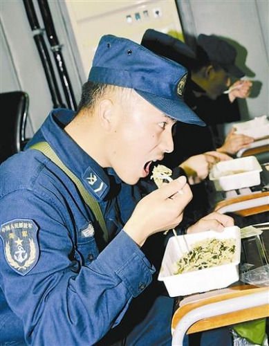 “青島”艦上的官兵在戰位上吃野戰快餐。圖片來源：解放軍報 記者 米晉國攝