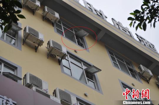 圖為欲跳樓的男子一腳跨在酒店房間窗臺上。　何楊　攝src=