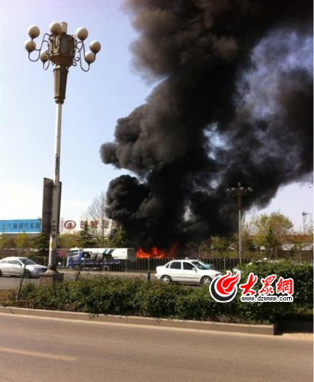 78路公交車自燃濃煙達(dá)二三十米高，圖中著火處附近是一輛幫忙滅火的綠化車。（圖片源自網(wǎng)絡(luò)）