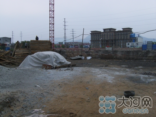 施工人員正在偌大的地基旁緊張的忙碌著