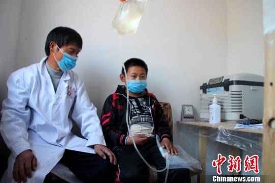 李清中在自制的“透析室”為兒子李凱做腹膜透析。　張帆攝