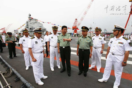 習近平一直十分關心我國第一艘航空母艦建設和部隊訓練。28日上午，他一下飛機就冒著風雨來到海軍某艦載機綜合試驗訓練基地，觀看艦載機滑躍起飛、阻攔著陸訓練，實地察看有關設備。當天下午，習近平又風雨兼程趕往大連，登上停泊在大連港的遼寧艦。攝影：解放軍報記者周朝榮