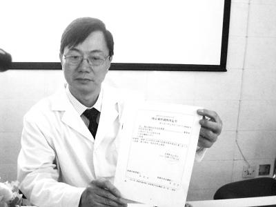 圖為肖傳國拿著深圳市公安局龍崗分局出具的終止案件調(diào)查決定書。