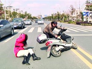 幫她扶起電動車。