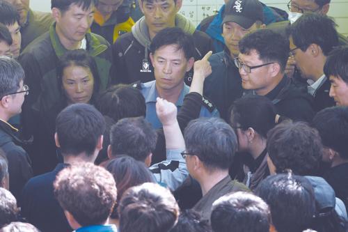 24日，韓國(guó)沉船遇難者家屬將韓國(guó)海警隊(duì)士兵以及政府官員拖出辦公室，要求政府提高搜救的速度與效率。
