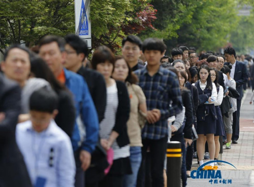 4月26日，在韓國安山一處臨時客輪遇難者紀念堂附近，民眾排起長隊前來悼念這些逝去的人。（圖片來源：英國媒體） 