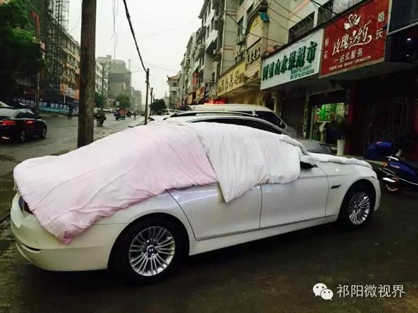永州祁陽(yáng)街頭，蓋著被子的寶馬車。供圖/網(wǎng)友
