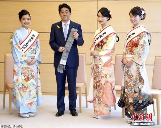 當地時間2015年12月8日，日本東京，首相安倍晉三在官邸接見“和服女王”，并獲贈傳統和服腰帶。