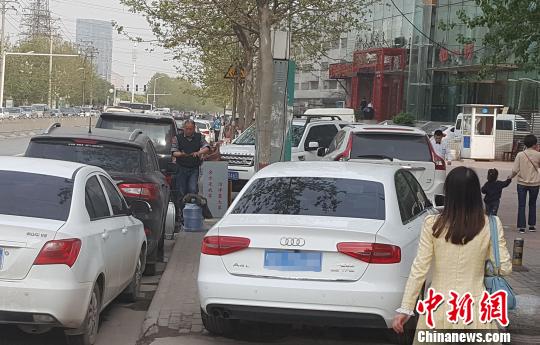 圖為鄭州市東風路一飯店門前人行道、盲道、非機動車道停滿了各式車輛，行人艱難通過。附件停車場管理人說，交了停車費他負責協調交警不貼條?！↓R永 攝