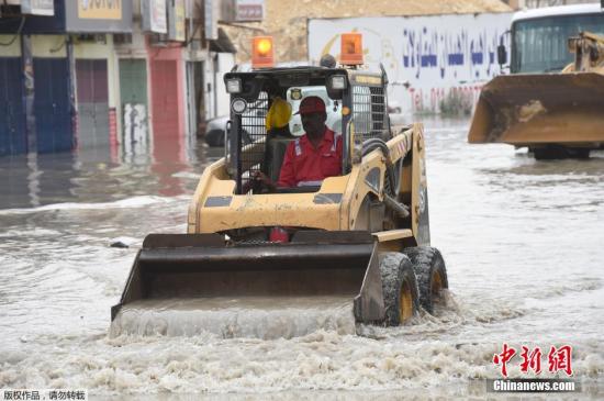 當地時間2016年4月13日，沙特首都利雅得，暴雨致街道被淹，市政工人清理積水。受天氣影響，沙特許多學校停課。