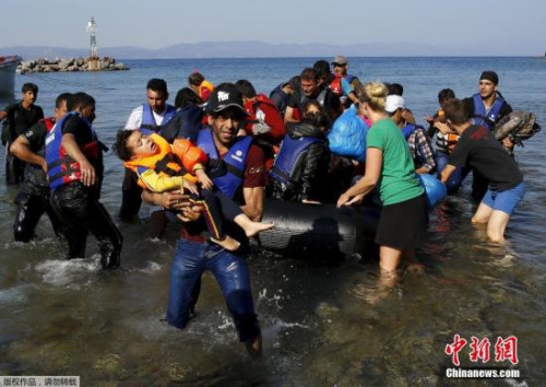 資料圖：2015年9月20日，大批的難民從海上偷渡到土耳其，超載的船只在海上漂泊，救援人員拋下繩索解救了這一船難民。
