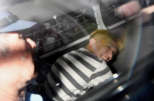 　犯罪嫌疑人植松圣在警車里面露微笑。(圖片來源：美聯社)