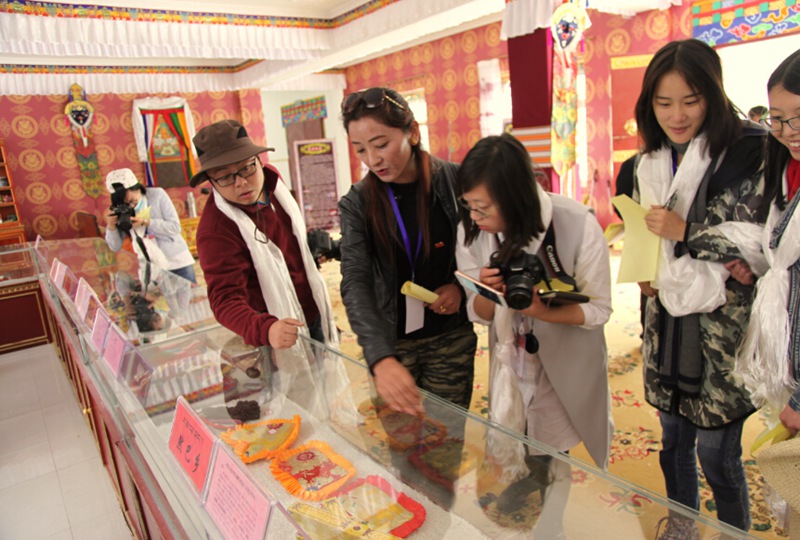 仁布縣旅游局長扎西澤措正在向媒體介紹藏族特色手工商品。