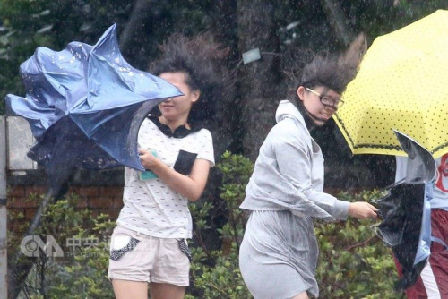 走在臺北街頭的民眾撐傘，仍抵擋不住強風的吹襲。臺灣”中央社”記者吳翊寧 攝