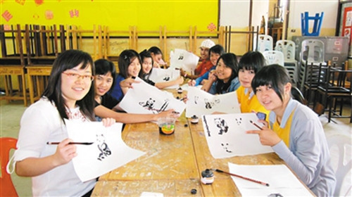 梁貞（左一）給泰國學生教畫大熊貓。
