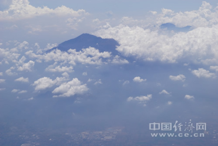 自2015年印尼對中國游客實施免簽征政策以來，除巴厘島、日惹等傳統旅游熱點，印尼政府積極向中國游客和投資者推介新的旅游目的地。圖為印尼中爪哇省旅游名城瑪瑯市郊的活火山——阿朱納火山，山腳下就是星羅棋布的村落，中方公司目前正協助當地開發火山相關旅游項目。中國經濟網記者田原 攝