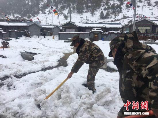 3月11日，西藏公安邊防總隊機動支隊應急二分隊官兵正在鏟除道路積雪。 張鈺 攝