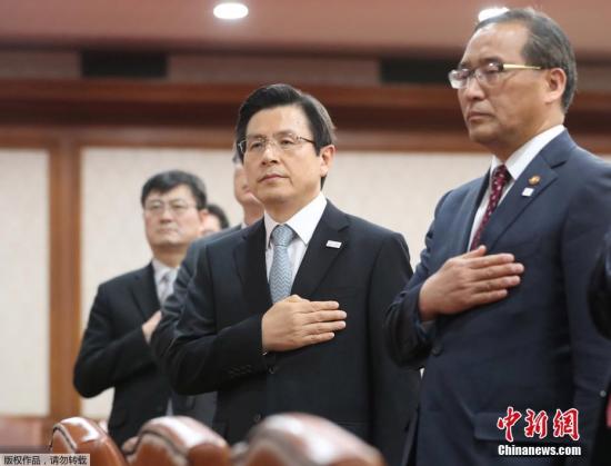 資料圖：韓國代總統(tǒng)黃教安(中)在會議上向韓國國旗致敬。在韓國前總統(tǒng)樸槿惠被彈劾后，黃教安曾向國民保證將恢復(fù)國政正常運營。