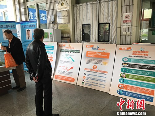 北京普仁醫院外，有人在細讀醫改宣傳板。湯琪 攝
