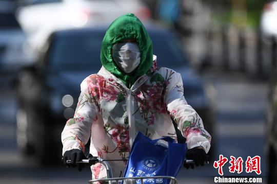 今年首次大范圍高溫來襲民眾烈日出行“全副武裝”