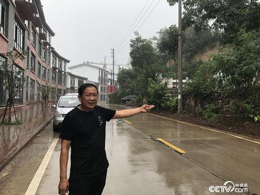 52歲趙書進手指著還沒有開發的舊房子，在他身后是自己即將開業的商鋪。（王莉莉 攝）
