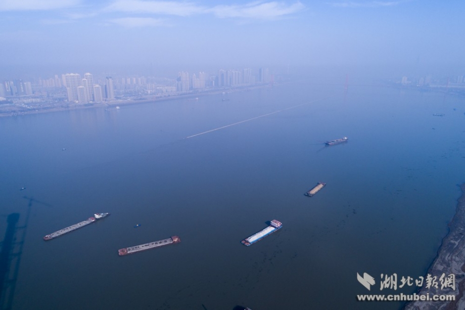 長江水深數十米，江面正中怎么會出現一條“道路”？據長江武漢航道局工作人員介紹，此處江面下是一處沙洲，這條路是在淺洲上修建的整治建筑物，用于穩定沙灘，確保航道通暢。
