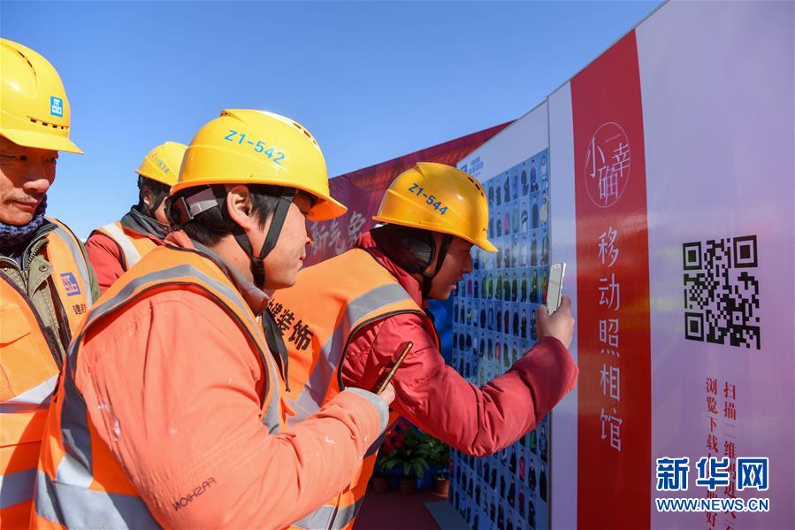 (新春走基層)(4)慰問新區建設者 “小確幸”移動照相館陪伴工人過大年